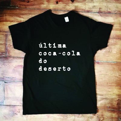T-shirt preta com texto branco 'última coca-cola do deserto'