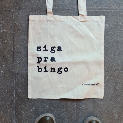 Mala de tecido bege clara com texto 