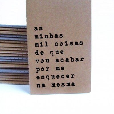 Caderno de capa castanha com texto em preto sobre fundo branco