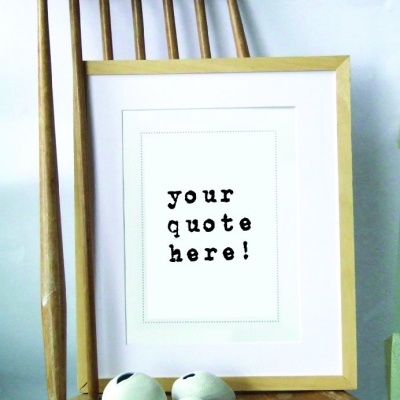 Moldura de madeira clara com pôster 'your quote here!' num banco de madeira rústica com três objetos decorativos brancos