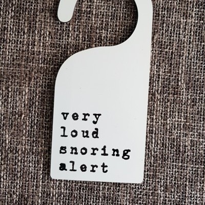 Gancho de porta branco com texto 'very loud snoring alert'