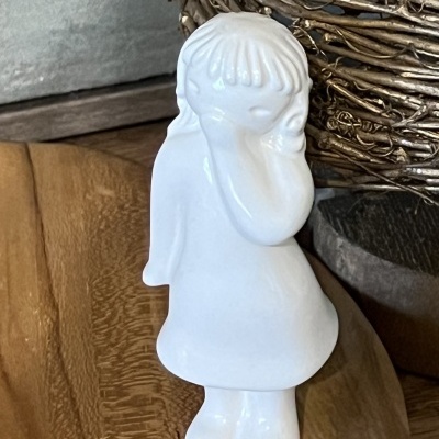 Figura decorativa em cerâmica branca de criança com vestido e cabelo curto