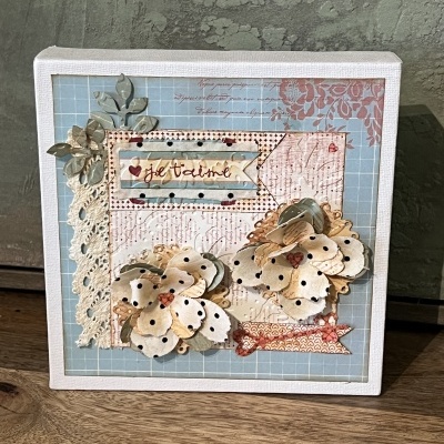 Caixa decorativa com flores de papel, renda branca e texto 'je t'aime'