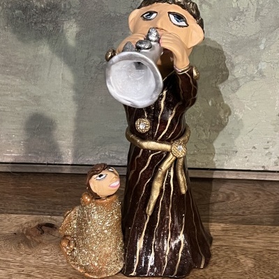 Escultura decorativa de figuras com trompete e roupa com glitter sobre madeira