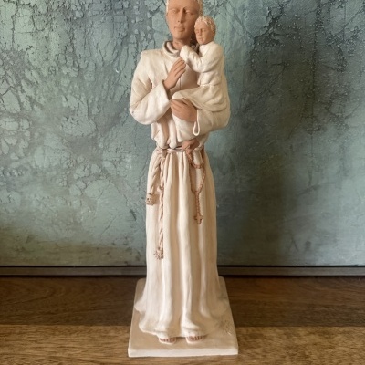 Estatueta religiosa de santo com menino ao colo em tons bege e branco