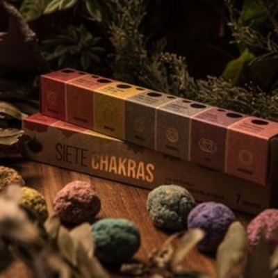 Conjunto de caixas coloridas dos sete chakras em caixa maior Siete Chakras com bolas coloridas e plantas ao fundo