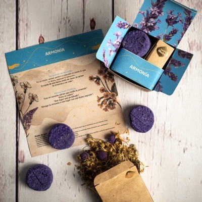 Caixas azuis com discos roxos e saco castanho com ervas secas numa mesa de madeira clara