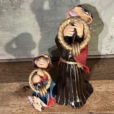 Duas figuras de cerâmica de monges com túnicas castanhas e capas coloridas segurando cordas douradas