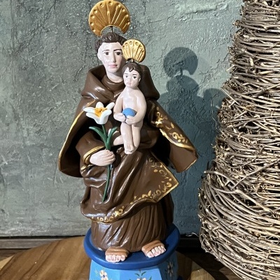 Estátua religiosa de Santo António com o Menino Jesus em resina pintada com base azul decorada.