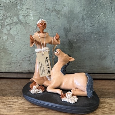 Figurine de homem com burro em base preta numa superfície de madeira