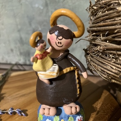 Estatueta de santo pintada à mão com criança e base decorada com flores