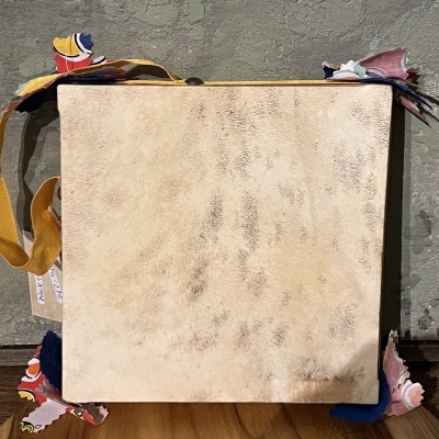 Caixa quadrada clara com cantos decorativos de tecido colorido e fita amarela