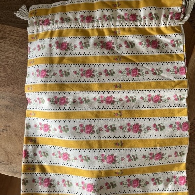 Saco de algodão com padrão de riscas amarelas e flores cor de rosa