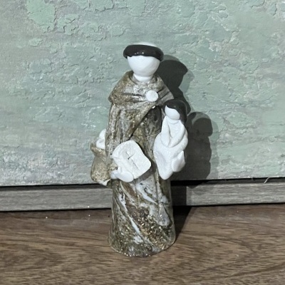 Figura decorativa de santa em cerâmica com menino ao colo sobre madeira