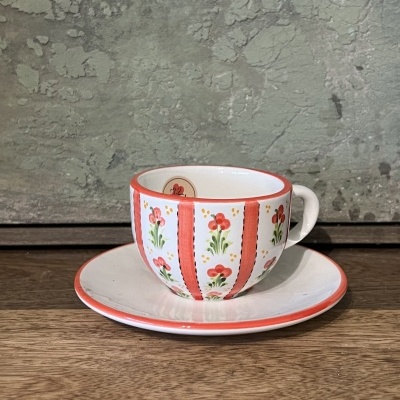 Conjunto de chávena e prato em cerâmica com decoração floral e bordas laranja-avermelhadas