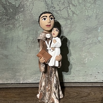 Figura de santo em madeira a segurar criança vestida de branco