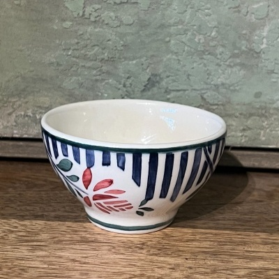 Taça de cerâmica com padrão de riscas azuis e flor vermelha