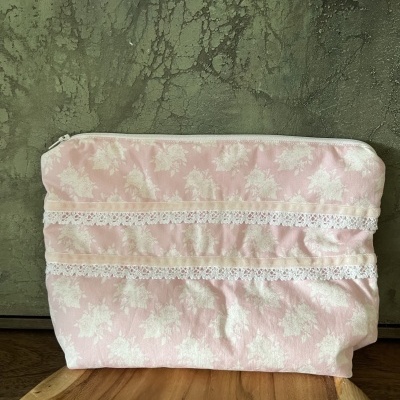 Necessaire rosa com padrão floral branco e rendas brancas