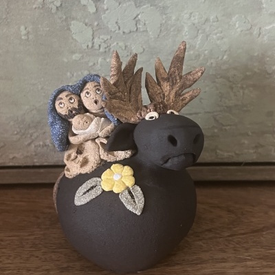 Estátua de cerâmica de alce com bonecos e flor