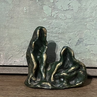 Escultura abstrata em verde e dourado de figuras humanas