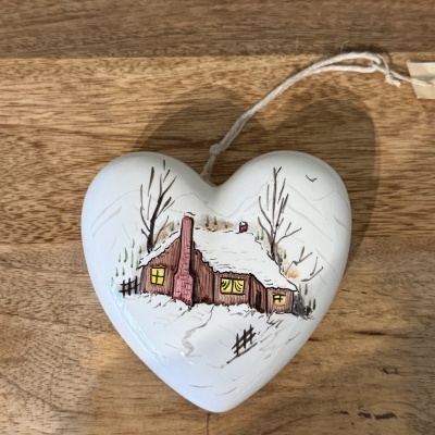 Ornamento branco em forma de coração com pintura de casa de neve