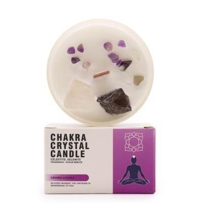 Vela Chakra Crystal Candle com cristais em recipiente branco em cima de caixa roxa e branca com texto e figura meditativa