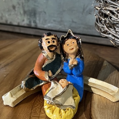 Figuras decorativas da Sagrada Família em cerâmica sobre tabuleiro de madeira