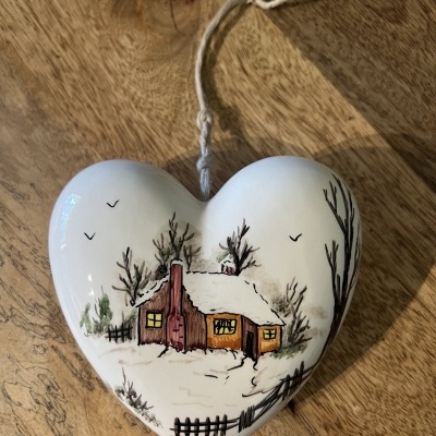 Ornamento coração cerâmico com pintura de casa e paisagem de inverno.
