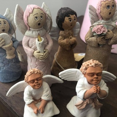 Figuras decorativas de anjos em cerâmica ou barro, varias cores e texturas, algumas segurando objetos