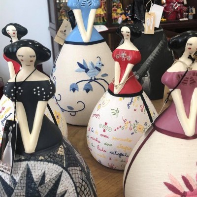 Figuras femininas decorativas em cerâmica com vestidos coloridos e padrões variados