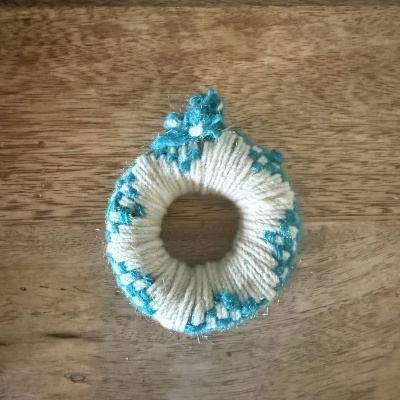 Elástico de cabelo feito de fios brancos e azuis com ornamentos fluorescentes azuis