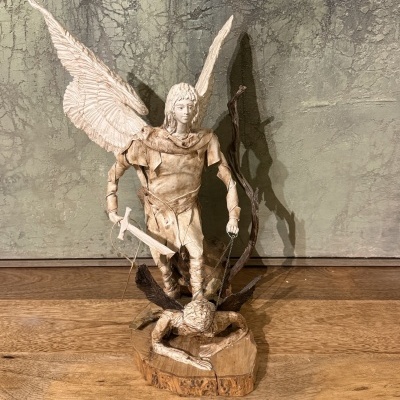 Estatueta de anjo com espada e corrente sobre base de madeira