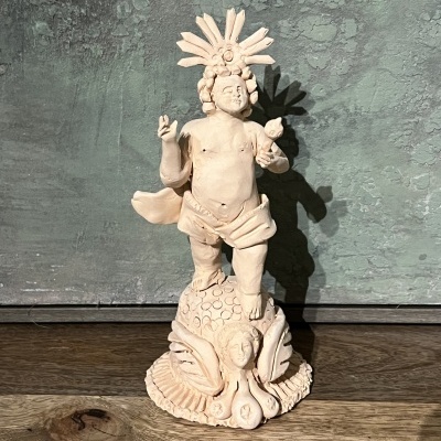 Estátua de cerâmica decorativa com figura humana e adorno de penas