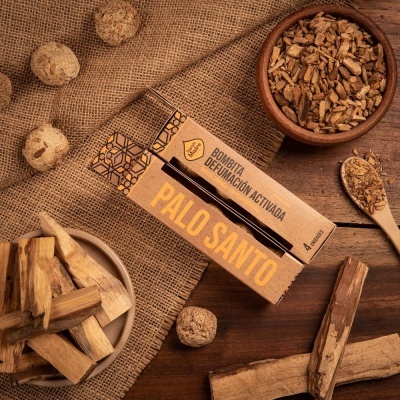 Embalagens de Palo Santo e elementos naturais de madeira e cascas sobre tecido de ráfia e madeira