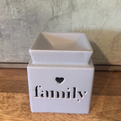 Quemador de cera de cerámica blanco con palabra family y corazón recortados