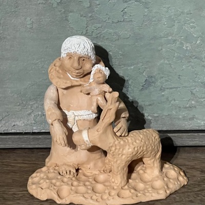 Estatueta em barro cozido de homem com criança e rena