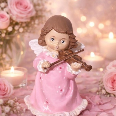 Figura decorativa de anjo em vestido rosa tocando violino com flores e velas ao fundo