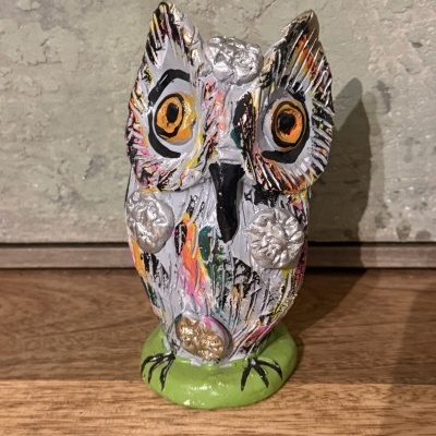 Estátua decorativa de coruja colorida em cerâmica.