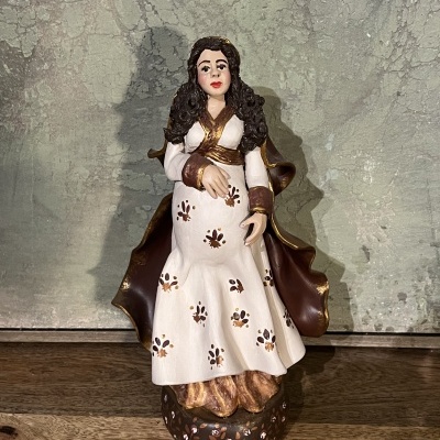 Estátua de mulher com vestido branco e capa castanha