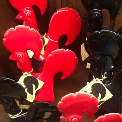 Figuras decorativas de galo em cerâmica vermelha e preta com etiquetas penduradas