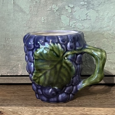 Caneca cerâmica formato cacho de uvas roxas com folha verde e pega verde