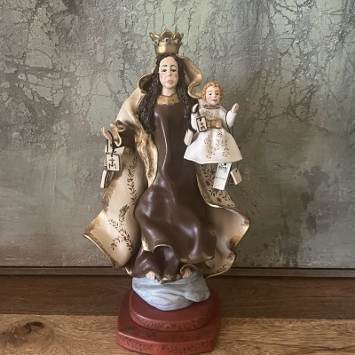 Estátua religiosa Nossa Senhora do Carmo com Menino Jesus em manto castanho e bege sobre base vermelha