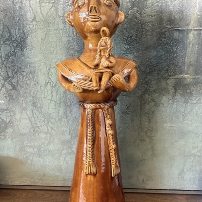 Estátua cerâmica castanha de figura humana com outra figura menor nos braços