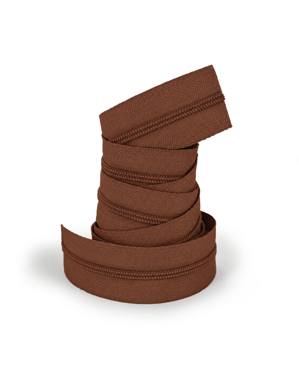 Rolo de fecho éclair de tecido castanho enrolado sobre fundo branco