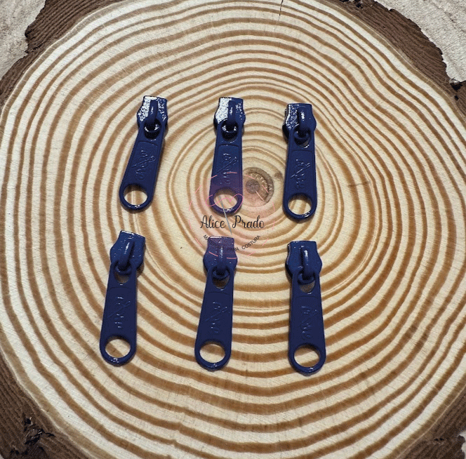 Seis puxadores de fecho éclair azuis sobre madeira com anéis concêntricos