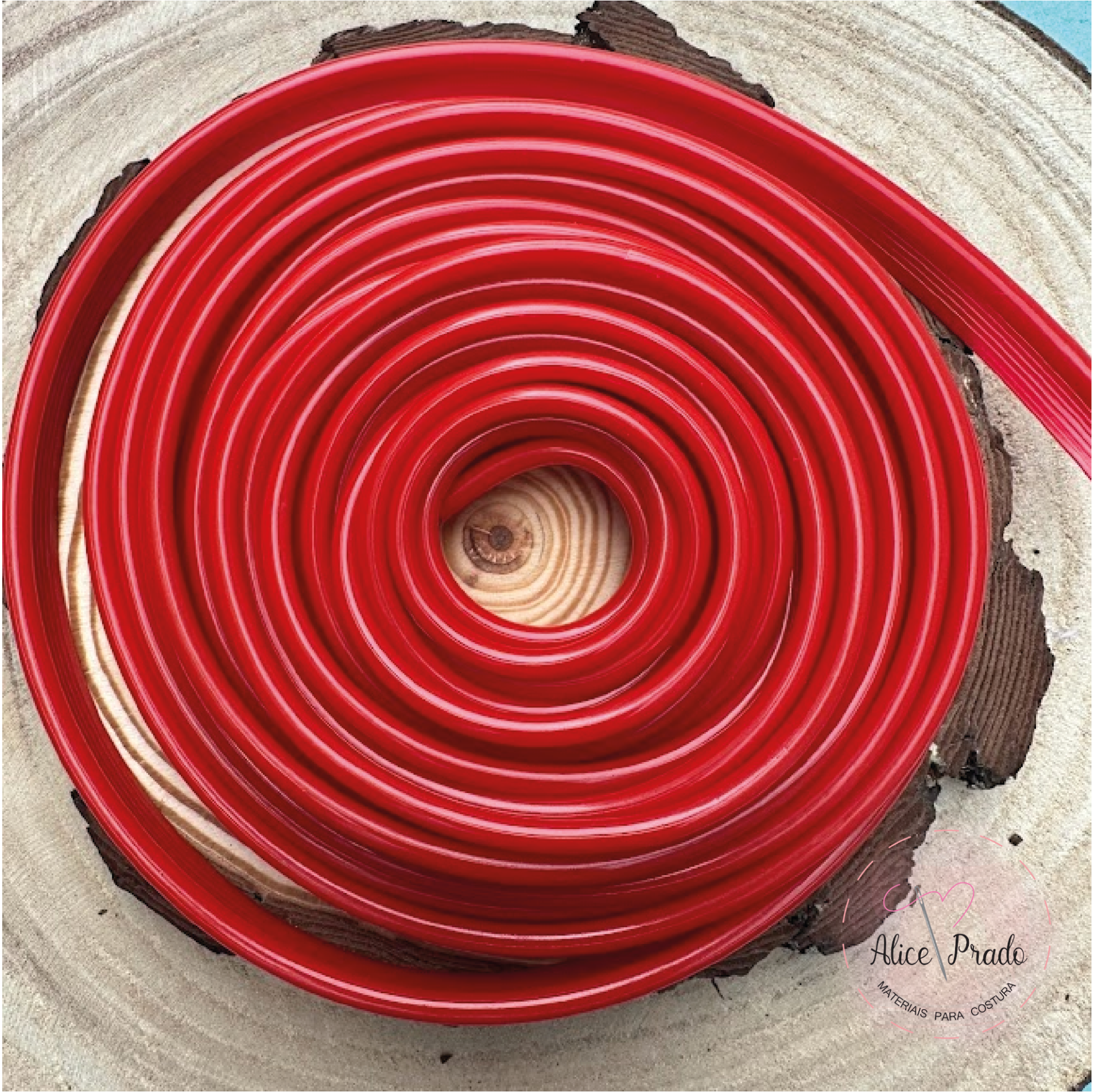 Cabo elétrico vermelho enrolado em espiral sobre superfície de madeira