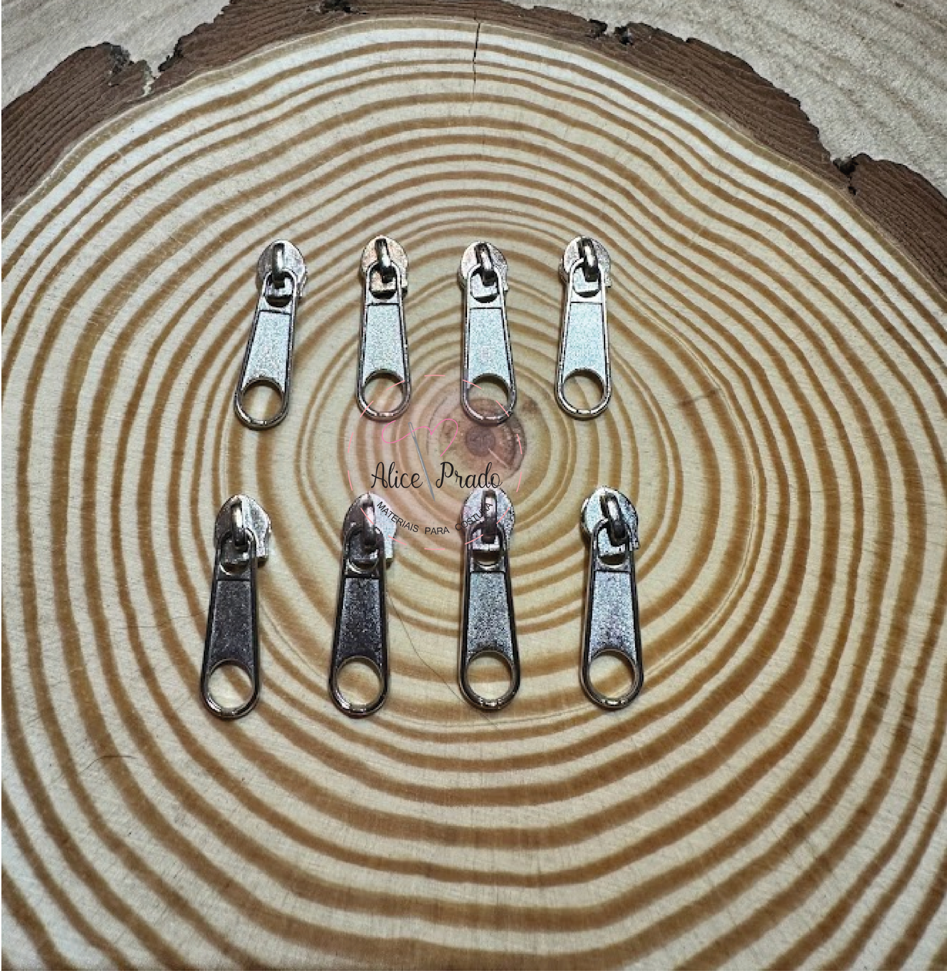 Oito carrinhos metálicos para fechos de correr sobre superfície de madeira redonda