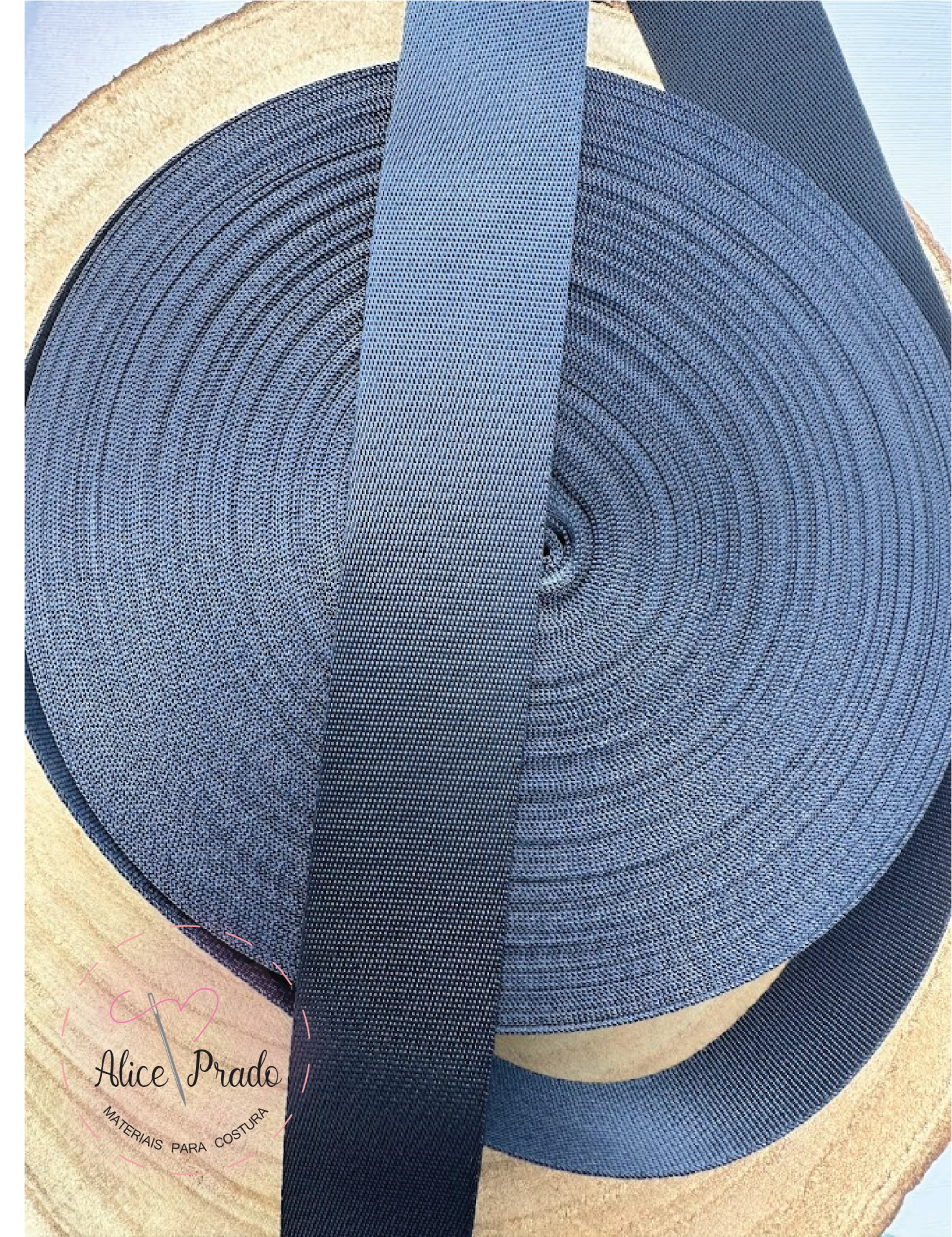 Fita elástica preta enrolada em carretel com texto Alice Prado no canto