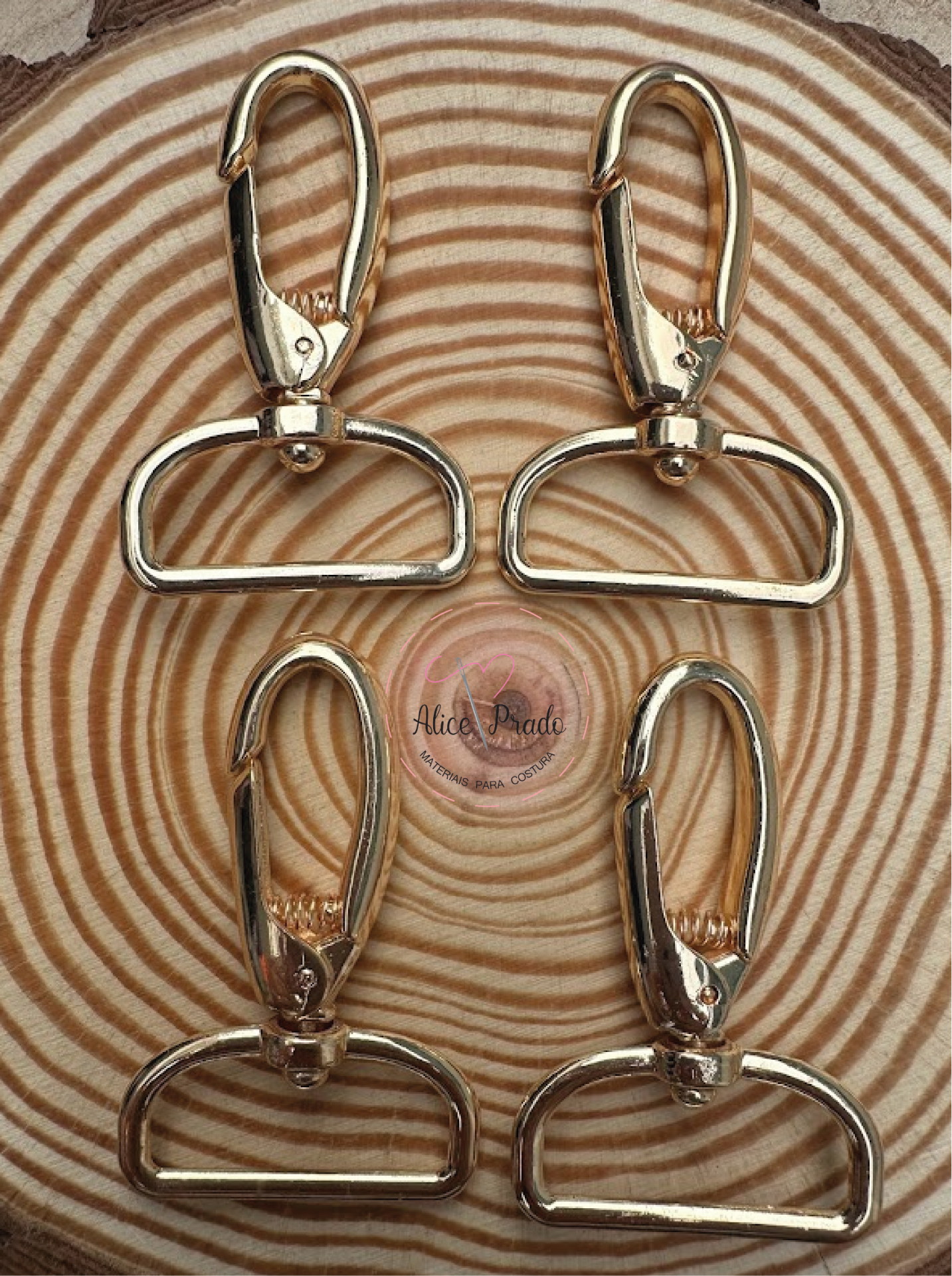 Mosquetões dourados sobre superfície de madeira com anéis