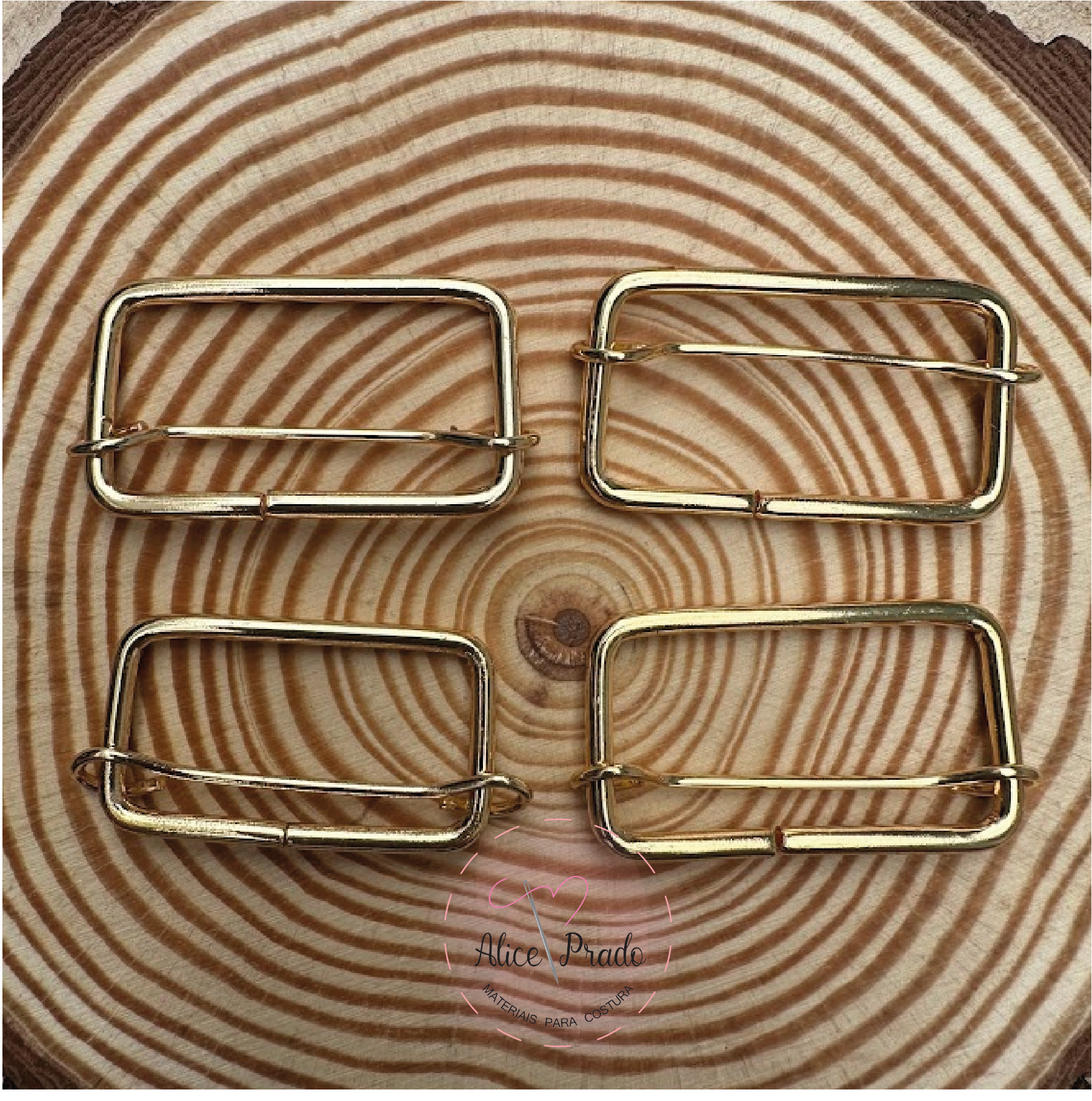 Quatro fivelas douradas retangulares em madeira com padrão circular.